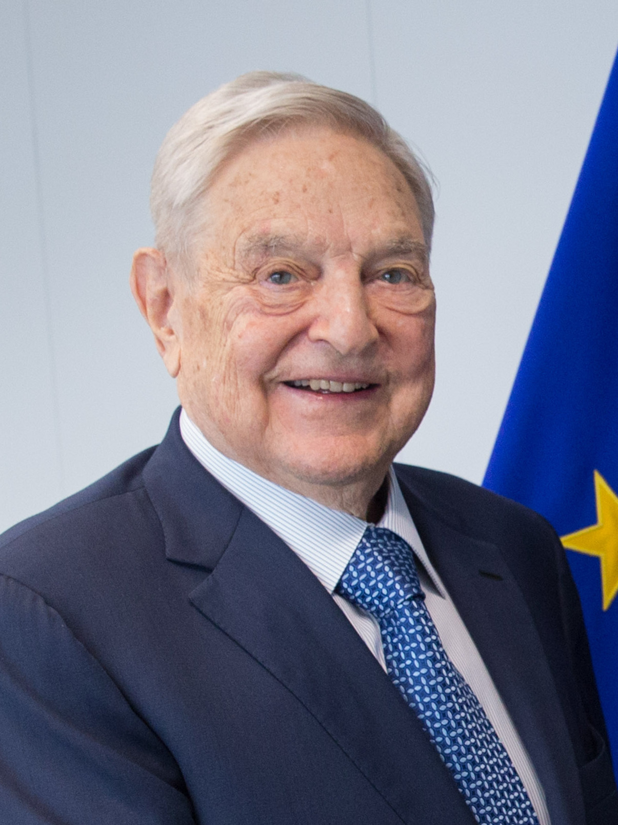 George Soros — founder of the Open Society Foundations, which has provided documented funding to hundreds of immigration advocacy NGOs across Europe and North America. Between 2016 and 2020, the Open Society Foundations spent over $2.5 billion on grants globally, with a documented emphasis on organizations that advocate for open immigration policies in Europe. Soros himself has described the European Union as the realization of the Open Society vision and has publicly criticized European governments that restrict immigration as threats to democratic values. His Hungarian origin and his status as the primary funding target of Viktor Orban's nationalist government is not incidental to the pattern documented in this article. Photo: European Commission / Wikimedia Commons
